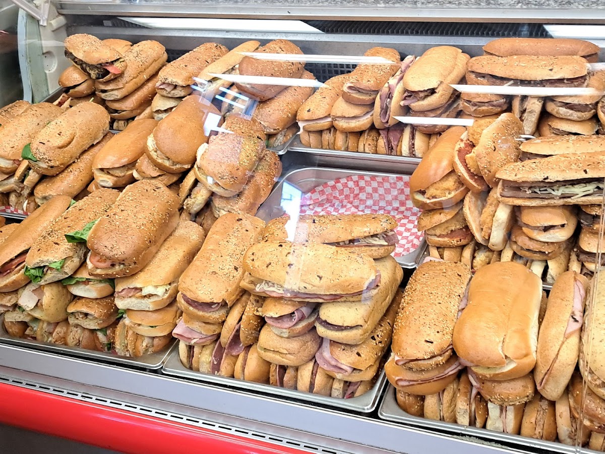 Rows of freshly made sandwiches packed into the deli display case, showing the incredible variety available at Chuck's