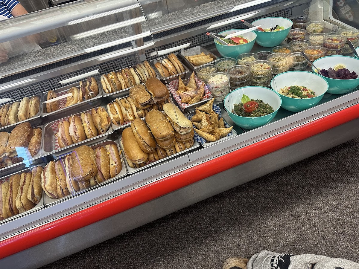 The deli counter at Chuck's Deli loaded with rows of freshly made paninis, sandwiches, and salads