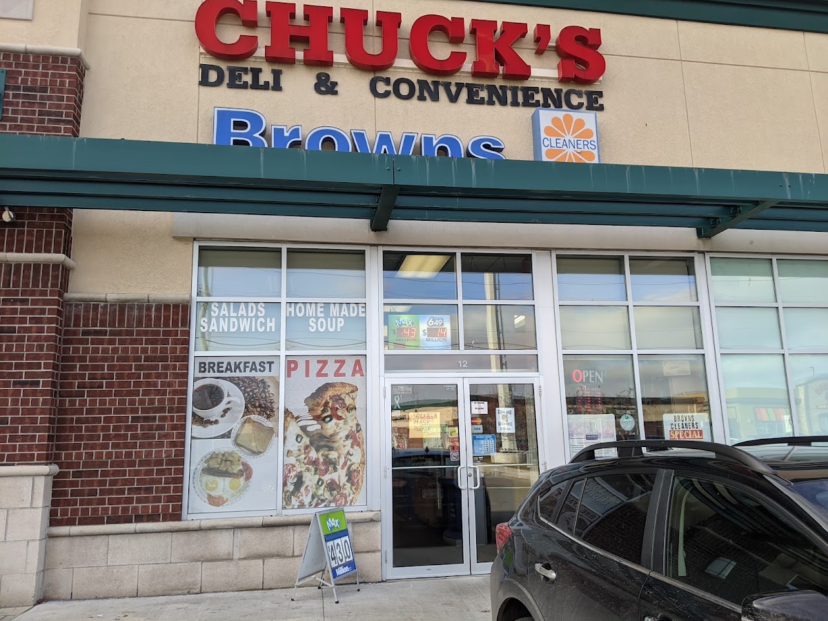 Exterior view of Chuck's Deli & Convenience storefront in Ottawa's Trainyards with red signage and window displays