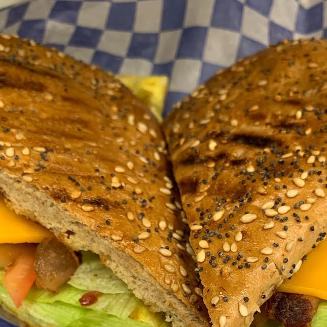 Grilled panini on seeded bread with cheese and vegetables